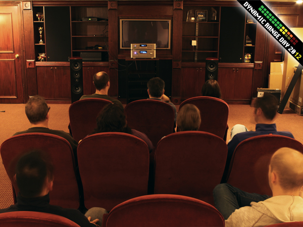 People sitting in a room listening to PSB speakers