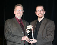 Two people holding an award